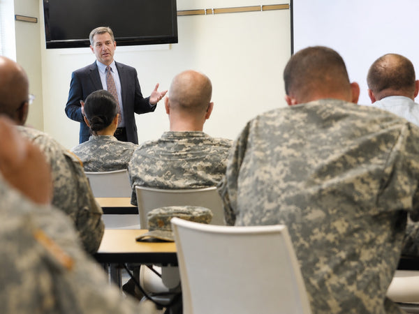 Resume specialist presenting a career transition briefing to service members in uniform
