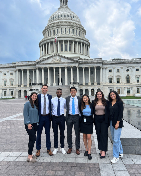 Group of professionals in business attire in front of the U.S. Capitol in Washington, D.C.